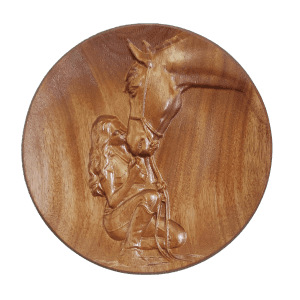 A wooden plate with a horse and rider carved into it.