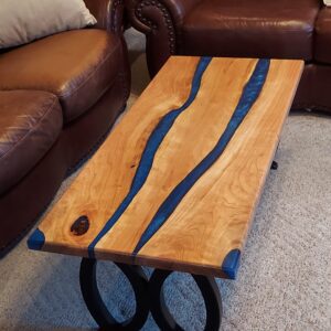 A coffee table with blue epoxy on top of it.